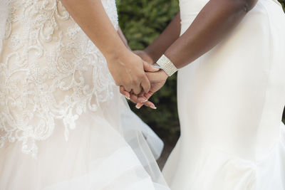 Midsection of couple holding hands