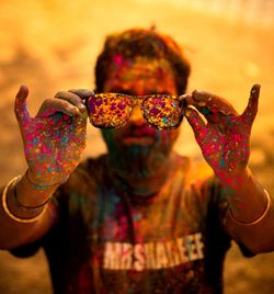 Man holding sunglasses during holi