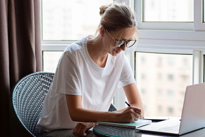 Side view of man using laptop at office