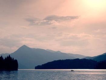 Abandoned tourist paddle boat on alps lake. evening lake glowing by sunlight.