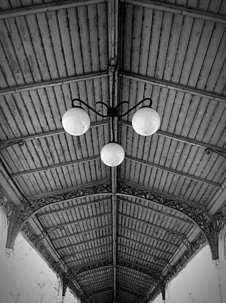 ceiling, indoors, built structure, architecture, illuminated, low angle view, lighting equipment, in a row, pattern, electricity, repetition, connection, diminishing perspective, no people, railroad station, transportation, modern, arch, architectural feature, interior