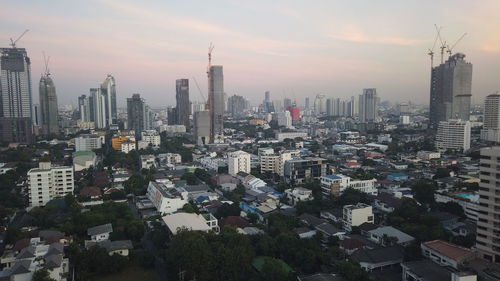 Aerial view of buildings in city against sky during sunset