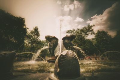 Man standing by fountain against trees