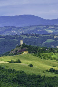 Scenic view of field by buildings against sky