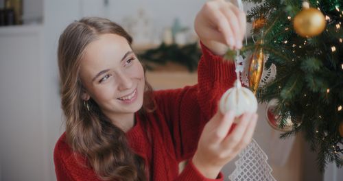 Portrait of young woman holding christmas decoration