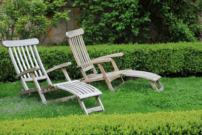 Empty chairs and table against grass