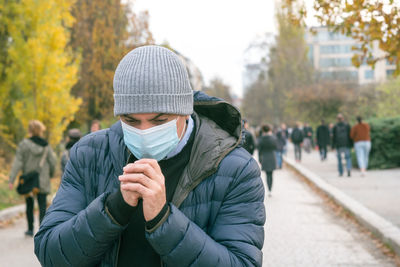 Incorrect way of sneezing or coughing into a protective  mask, outdoors. prevent the spread of covid