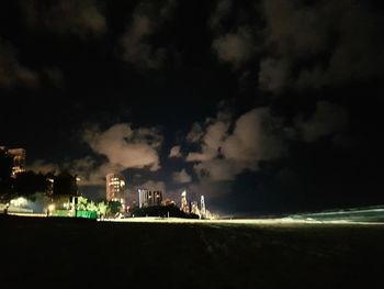 View of illuminated city against cloudy sky