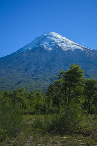 Scenic view of snowcapped mountains against clear blue sky