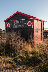 Information sign on field against sky