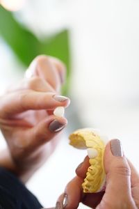 Midsection of woman holding a tooth 