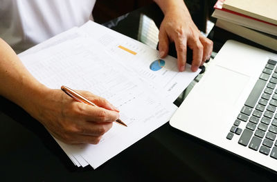 Midsection of man using mobile phone on table