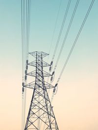 Low angle view of electricity pylon against clear sky