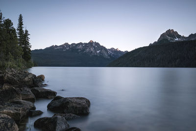 Scenic view of lake and mountains against clear sky