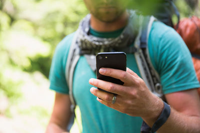 Midsection of man using mobile phone