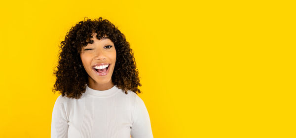 Portrait of a smiling young man against yellow background