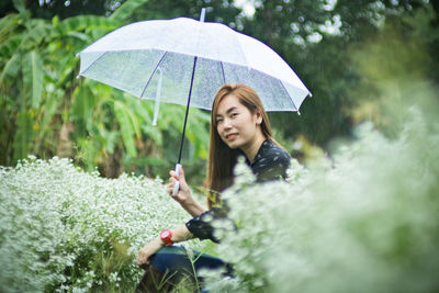 Full length of woman with umbrella in rain