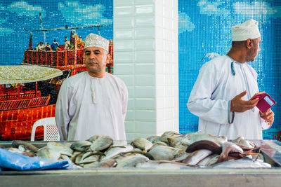 Man holding fish at market stall