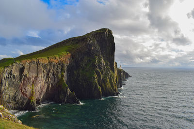 Scenic view of sea by cliff against sky