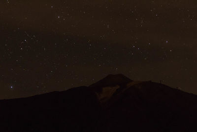Low angle view of silhouette mountain against sky at night