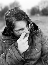 Close-up of teenage girl with hand on nose during winter