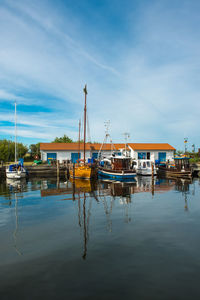 Boats moored at harbor against sky