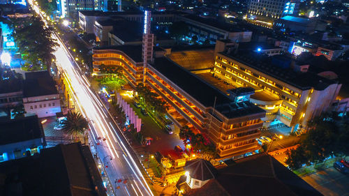 High angle view of illuminated street amidst buildings at night