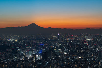 High angle view of illuminated cityscape against sky during sunset