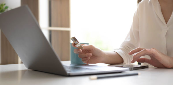 Midsection of woman using mobile phone