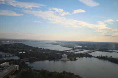 Aerial view of city by sea against sky