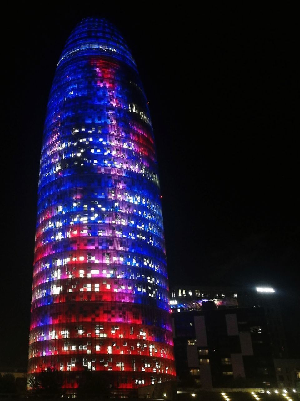 LOW ANGLE VIEW OF ILLUMINATED MODERN BUILDINGS AT NIGHT