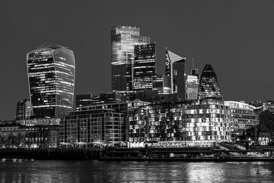 Illuminated buildings in city against sky at night