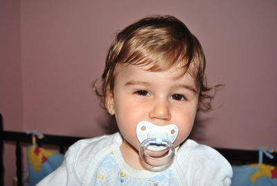 Portrait of baby boy sucking pacifier at home