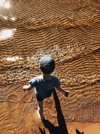 Rear view of boy on sand