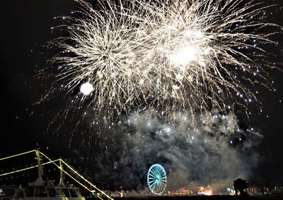 Low angle view of fireworks against sky at night