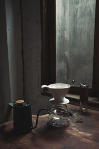 Coffee cup on table against window