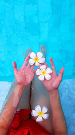 Low section of woman sitting at swimming pool