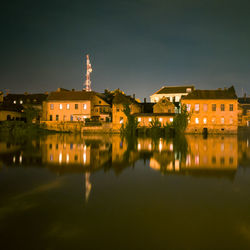 Illuminated houses against sky at night