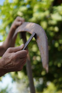 Cropped hands of man sharpening hand tool