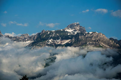 View of snowy peaks with alpine mountains landscape and clouds in saint-gervais-les-bains, france.