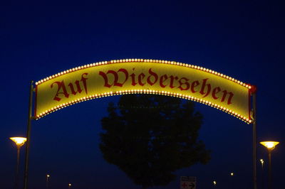 Low angle view of illuminated text against clear blue sky