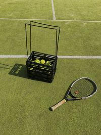 High angle view of tennis balls and racket on playing field