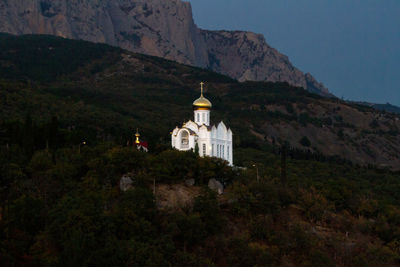 Low angle view of church on hill against mountain