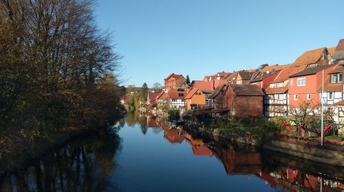 Canal amidst buildings against clear sky