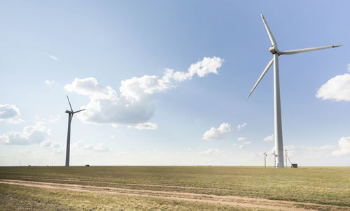 Panoramic over beautiful meadow field farm landscape, wind turbines, green energy, eco power