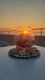 Close-up of shells on table against sky during sunset