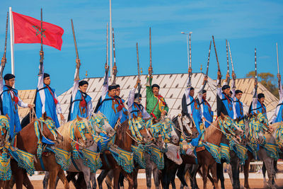 Panoramic view of people standing at beach against sky