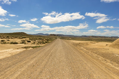 Road amidst desert against sky