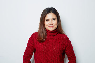 Portrait of a smiling young woman against white background
