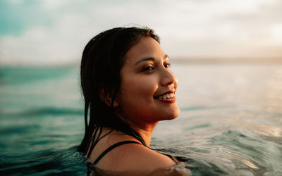 Portrait of young woman swimming in sea